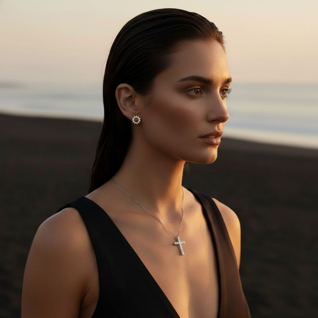 Colar com pendente de cruz em pavé prateado e dourado iluminado pelo sol